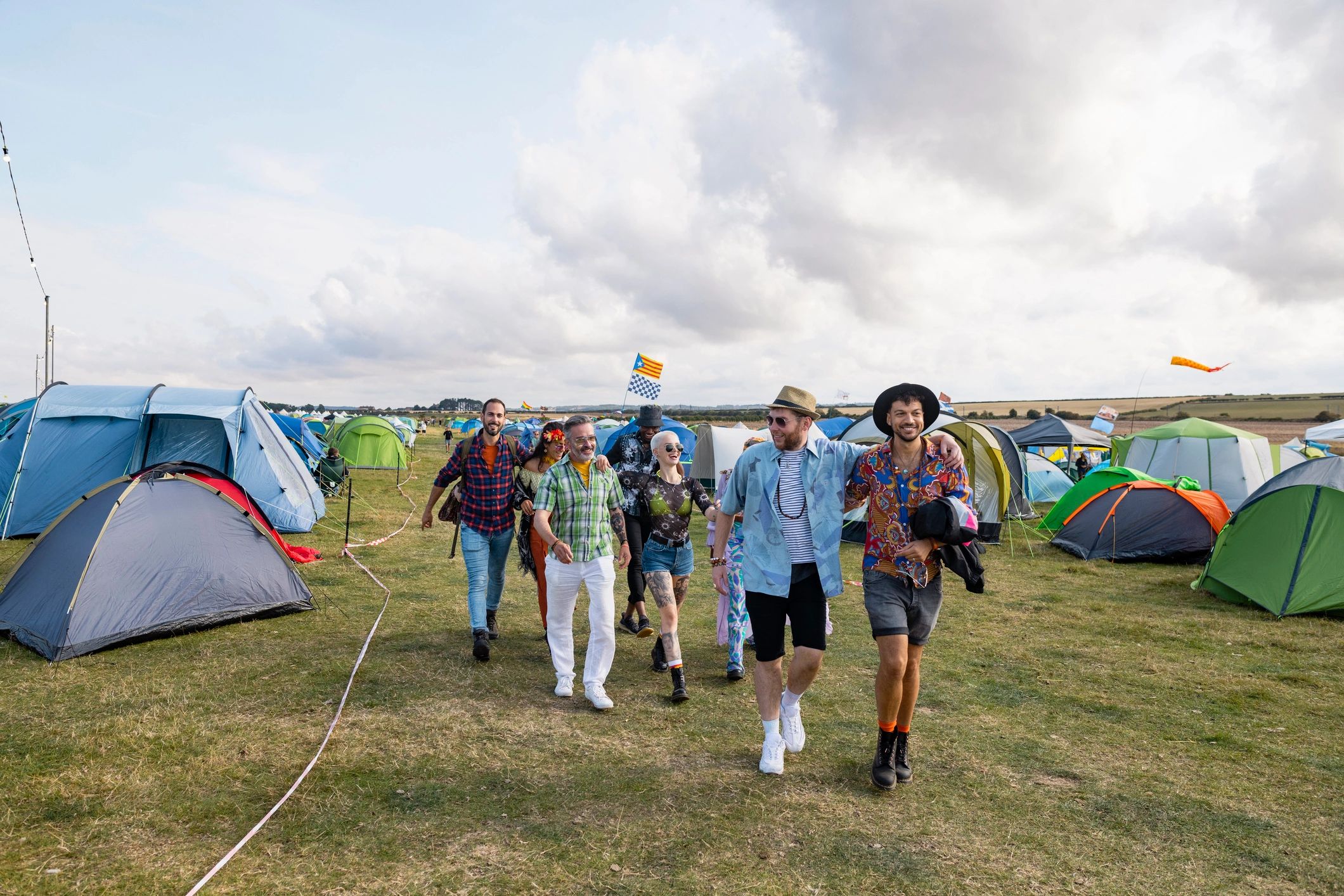 Festivalgoers walking toward a music area at an outdoor festival